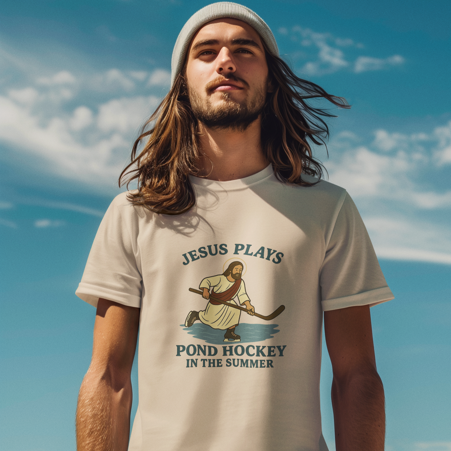 A man wearing the Jesus Plays Pond Hockey in the Summer shirt. Light tan with Jesus skating on water